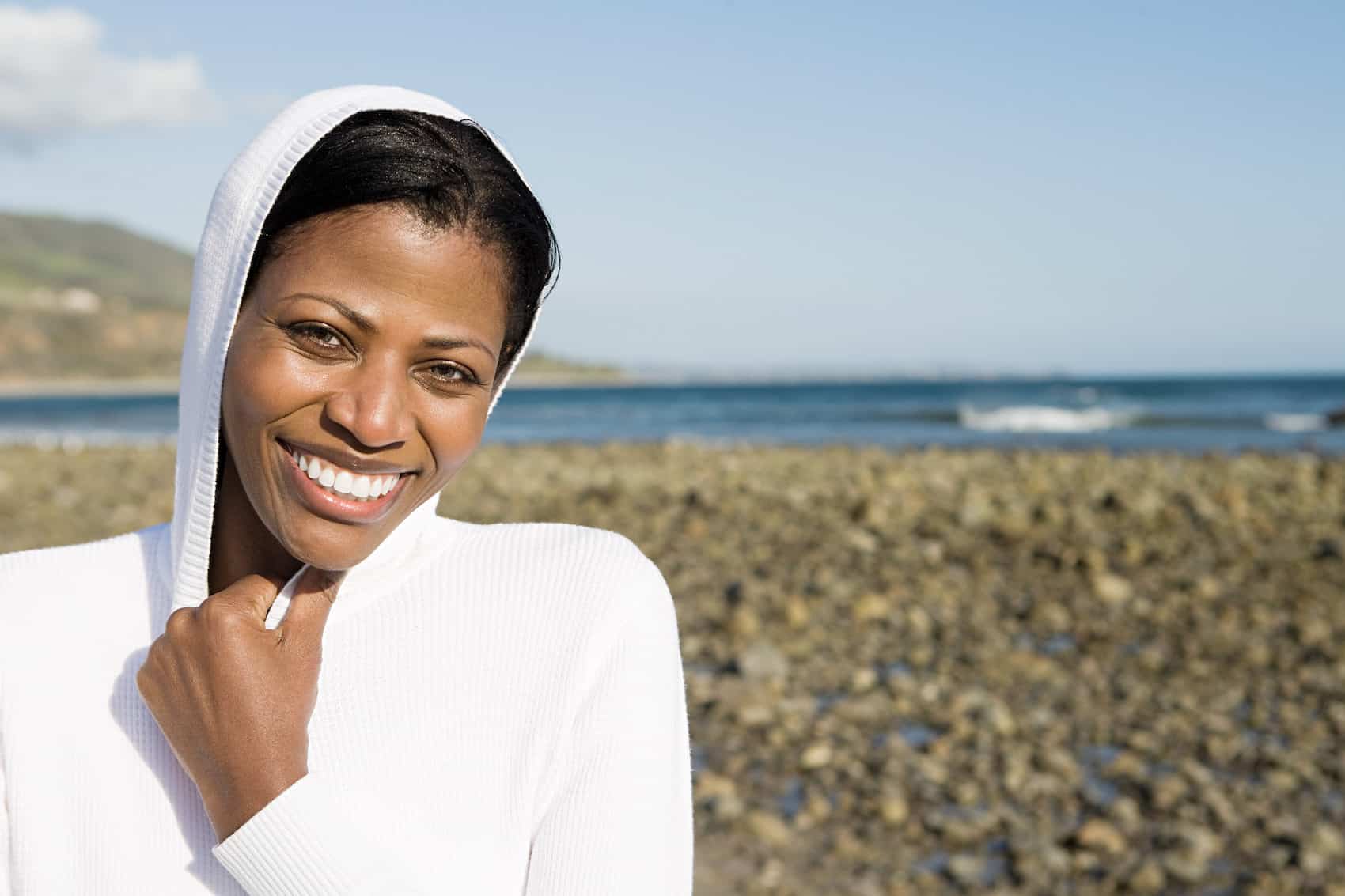 Smiling woman on a shingle beach