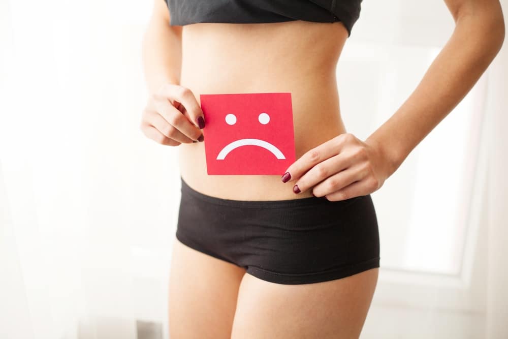 image of a sad face over a woman's stomach who needs uti treatment in katy